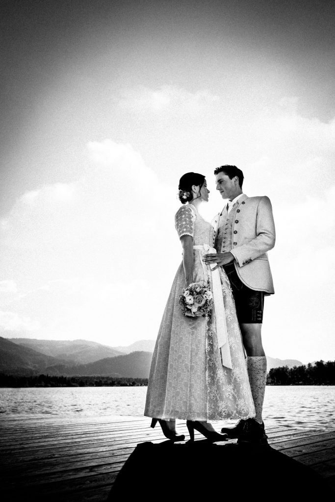 Hochzeitspaar steht auf einem Steg am Wolfgangsee